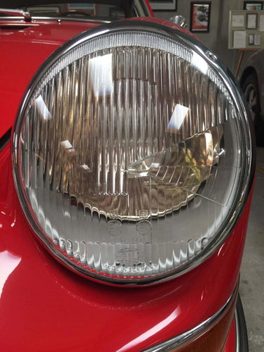 Close-up view of AC Gold Plus LED Headlights with fluted lens on a red vehicle.