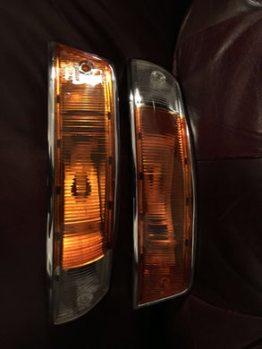 Porsche 911 SWB front turn signal restoration service showcasing restored lights on a leather background.